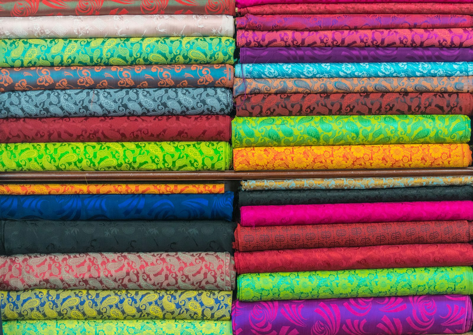 Folded bolts of natural woven fabric in a range of colors