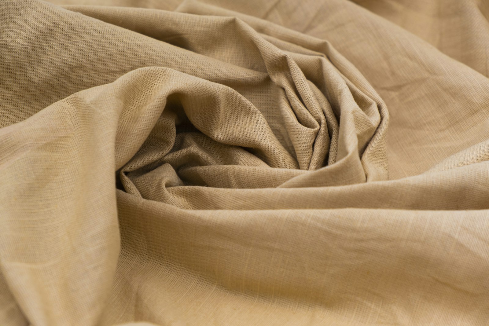 Gray wrinkled textile fabric resting on a wooden surface